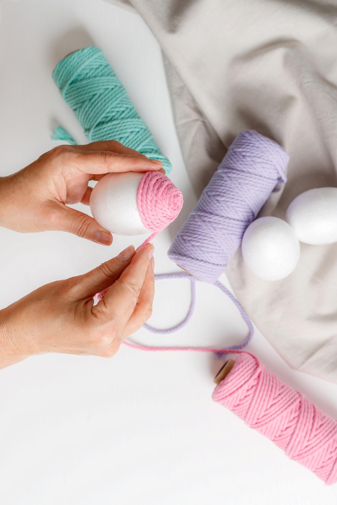 Hands arranging colorful threads